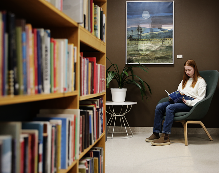 elev läser i biblioteket